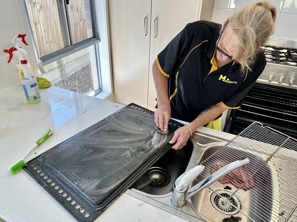 professional-cleaner-cleaning-oven-tray professional cleaner Liz cleaning the oven tray