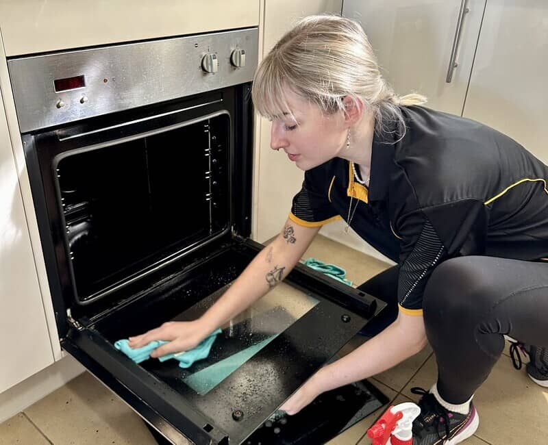 Maid2Match Brisbane professional house cleaner Casey cleaning oven door glass panes