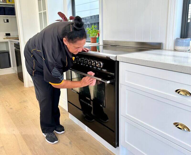 professional cleaner wiping oven glass door