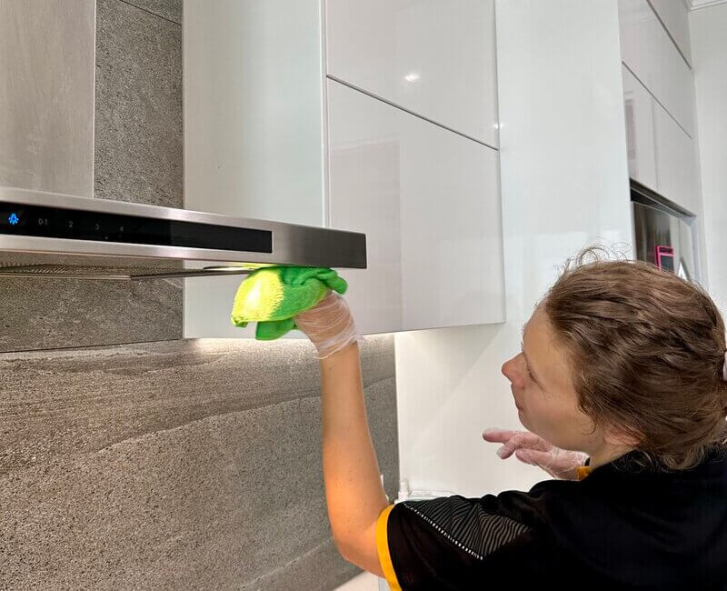 Maid2Match Gold Coast cleaner Acama cleaning the rangehood light covers