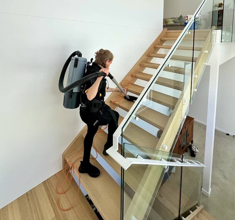 Maid2Match professional cleaner Nicole vacuuming the stairs