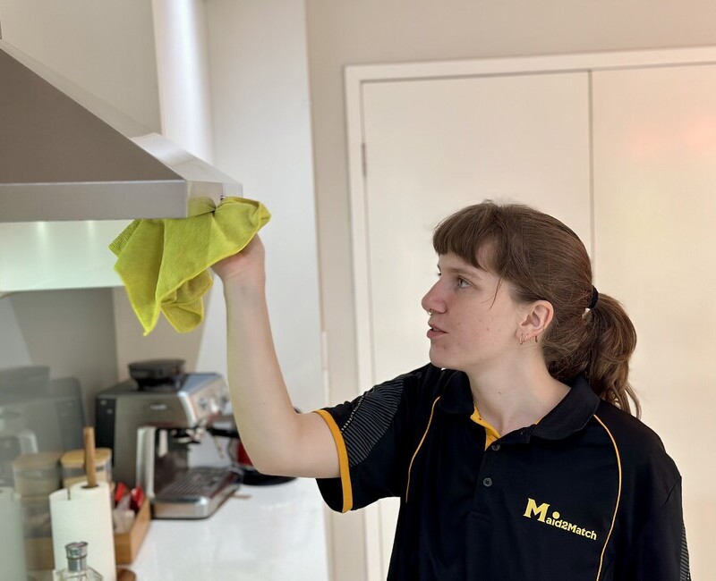 Professional cleaner Kayleigh cleaning the rangehood filter with microfibre cloth
