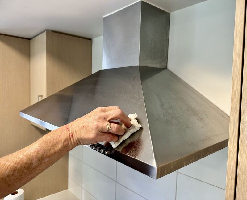 Hand cleaning a stainless steel rangehood with microfibre cloth