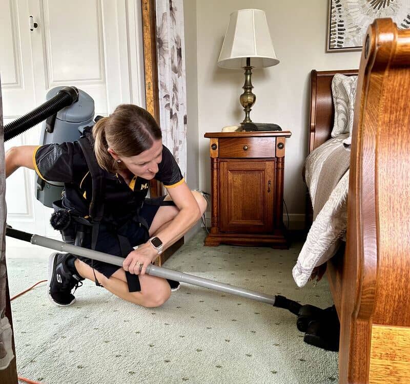 Maid2Match Lia vacuuming under the furnitures