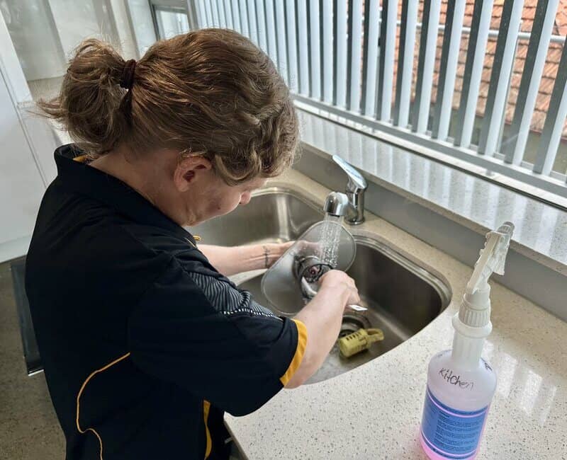 Nicole cleaning dishwasher filter with small brush