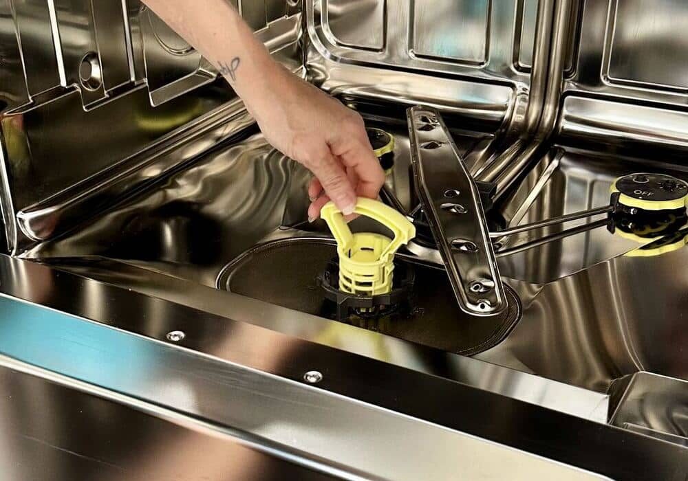 house-cleaner-taking-out-the-dishwasher-filter-for-cleaning House cleaner taking out the dishwasher filter at the bottom for cleaning