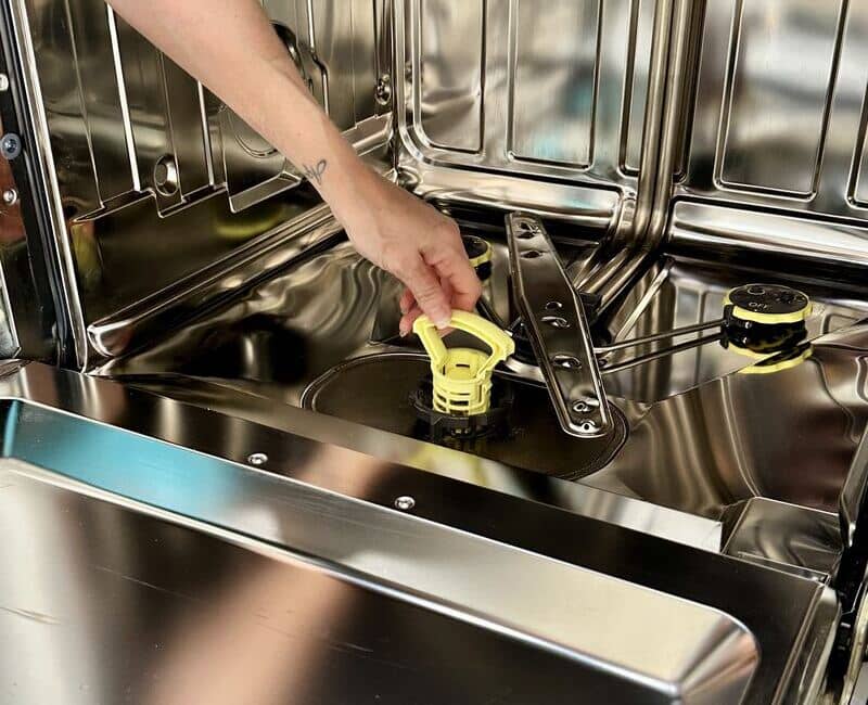 Maid2Match house cleaner taking out the dishwasher filter