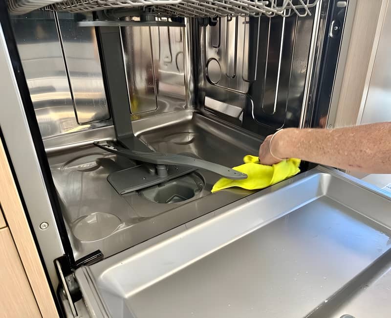 Maid2Match professional cleaner wiping the surfaces inside the dishwasher