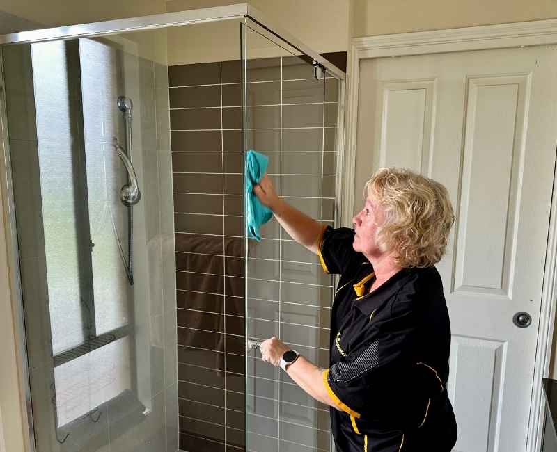 Maid2Match Gold Coast Field Staff Trainer and Professional House Cleaner Nicola cleans shower glass preventing limescale buildup
