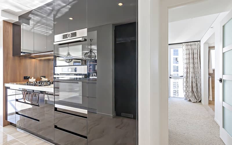 Kitchen pantry with high gloss cabinets close to room entrance