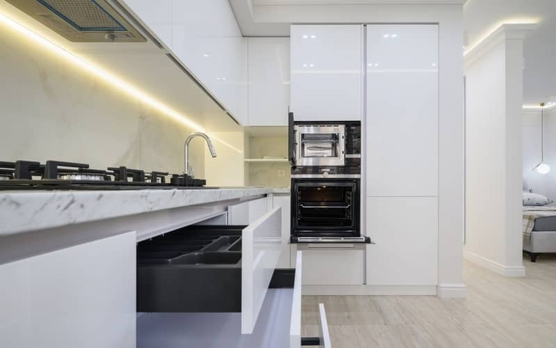 white modern kitchen with stove, oven, microwave, and polyurethane cabinets
