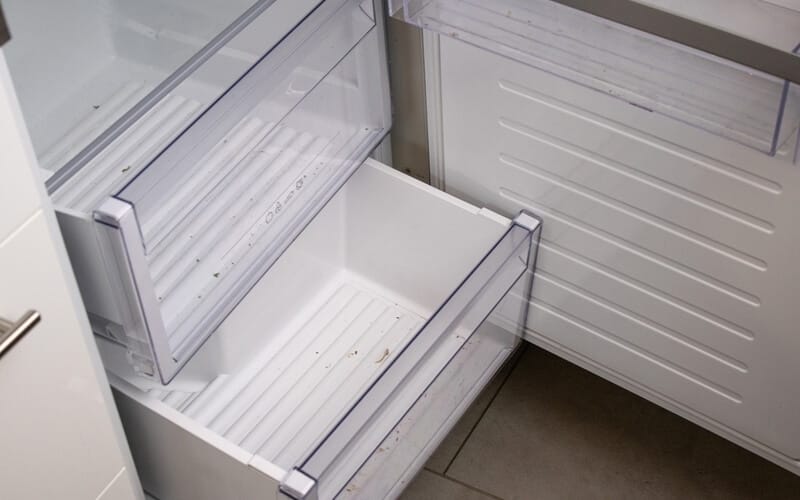 Close up of an open modern dirty refrigerator shelves that needs to be cleaned 