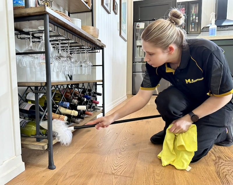 Kate-Lyn-Maid2Match-professional-cleaner-dusting-wine-bottles Kate-Lyn dusting a wine rack in a customer's home