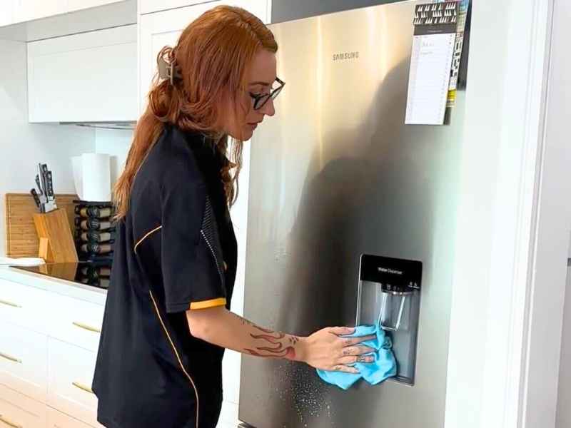 professional cleaner cleaning fridge water dispenser