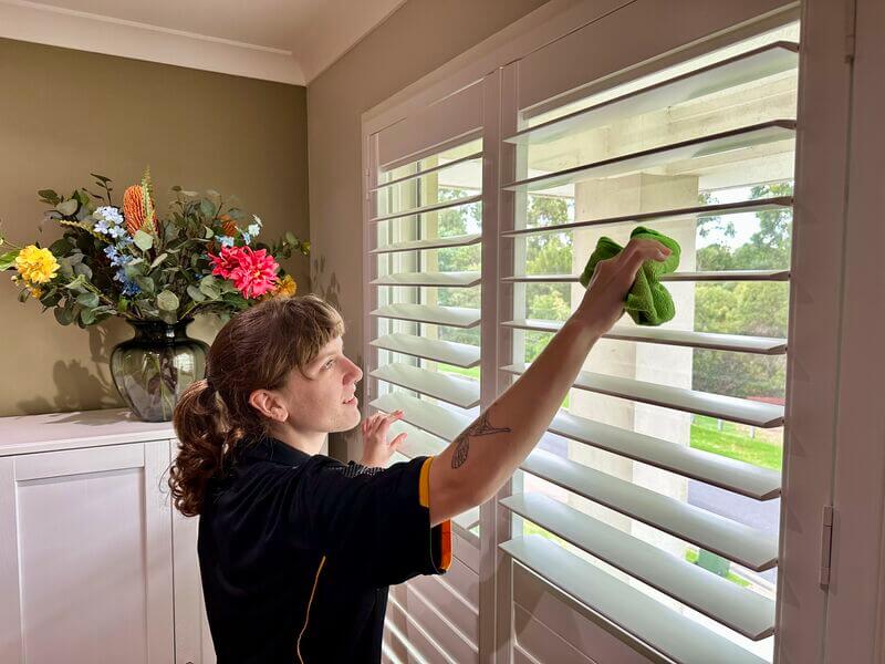 professional cleaner Kaitly cleaning the plantation shutters