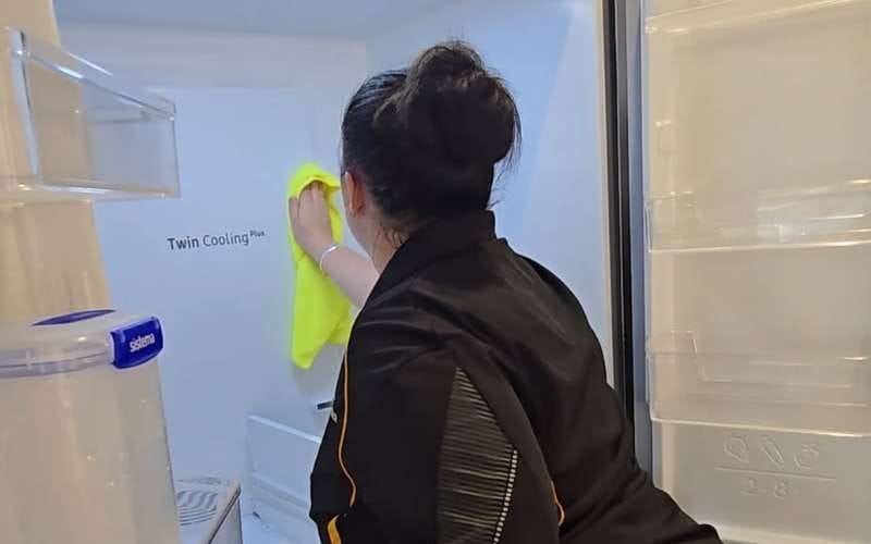 Maid2Match professional cleaner wiping fridge interior