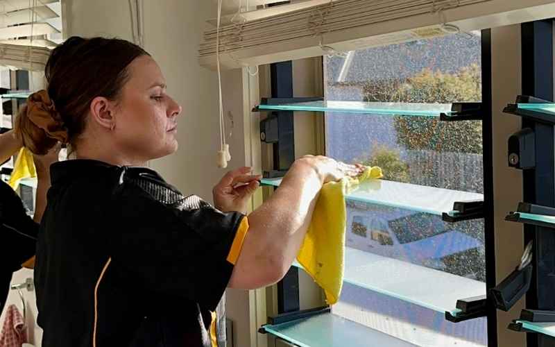 Maid2Match professional cleaner wiping glass windows