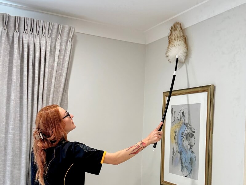 Maid2match house cleaner dusting the wall