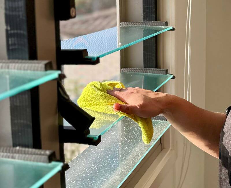 house cleaner cleaning glass louvre windows