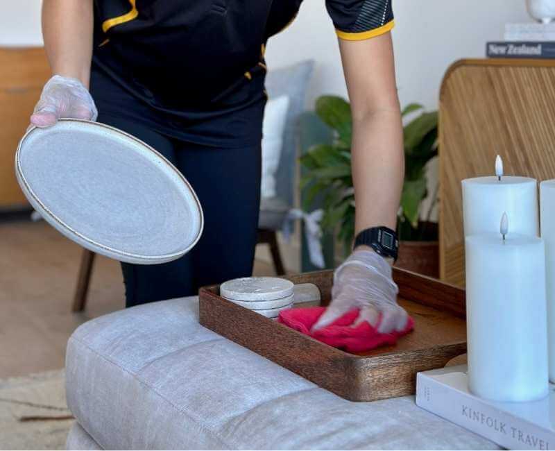 professional cleaner wiping wooden tray