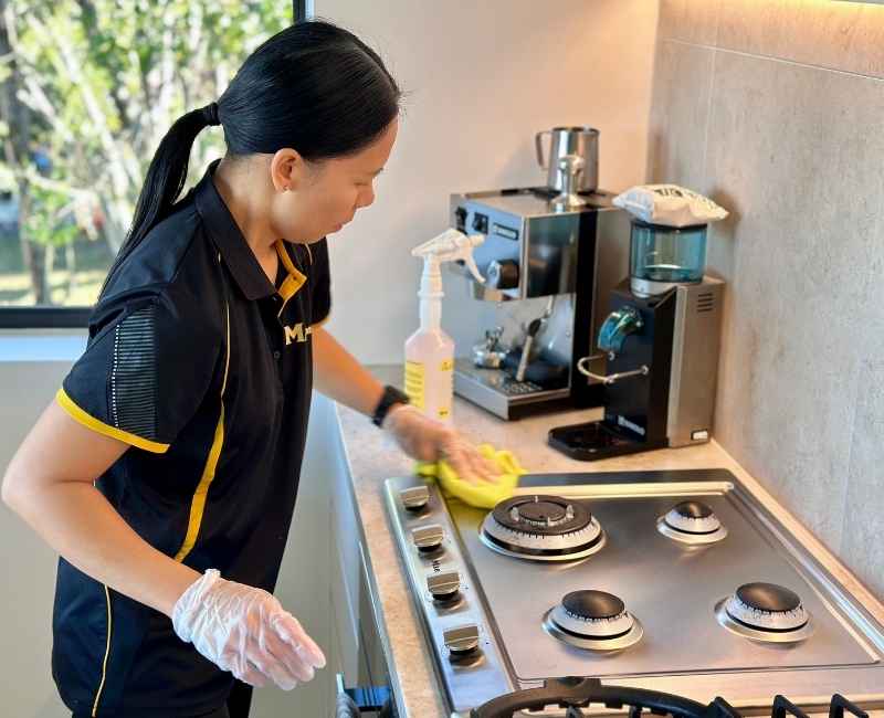 Brisbane Professional House cleaner Paige cleaning a stovetop