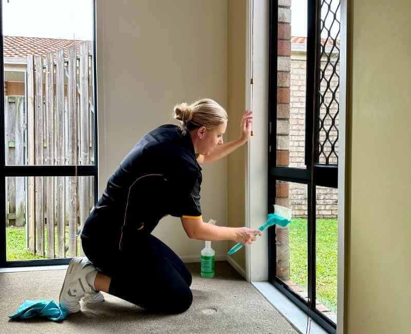 Brisbane professional house cleaner cleaning a window interior