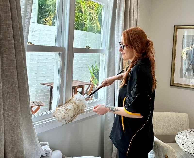 Maid2Match professional house cleaner dusting around living areas