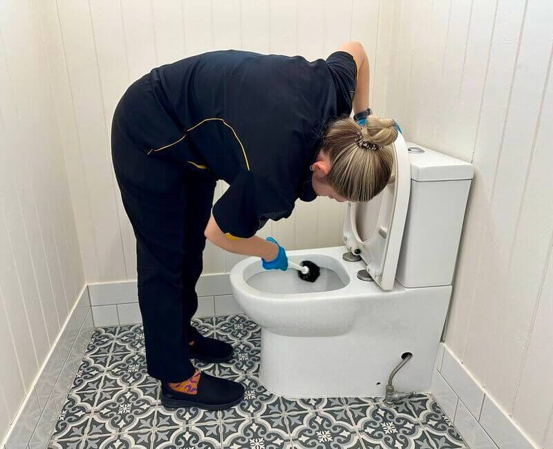 professional cleaner Kate-Lyn scrubbing the toilet with brush