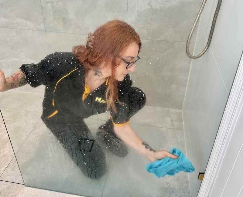 Maid2Match Brisbane Professional Cleaner, Mariachiara cleaning shower stains on glass shower surface
