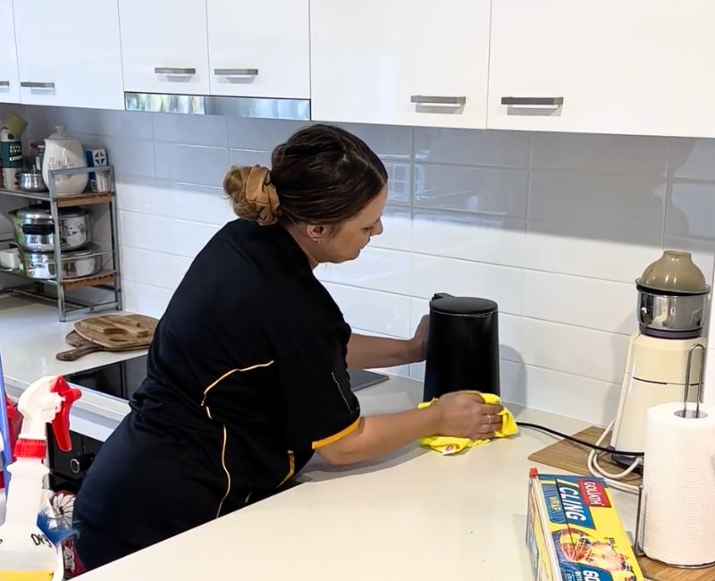 Maid2Match experienced house cleaner cleaning the base of a kettle