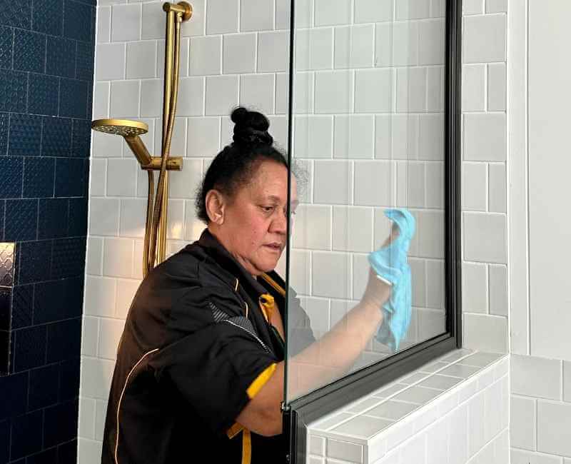 Maid2Match Brisbane Professional Cleaner, Janet cleaning shower glass using microfibre cloth