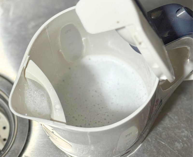 Dish soap and water soaking inside the kettle