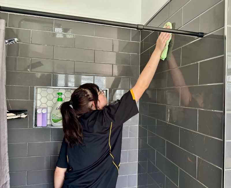 Maid2Match Brisbane professional cleaner, Tullie - cleaning tile shower surface with microfibre cloth