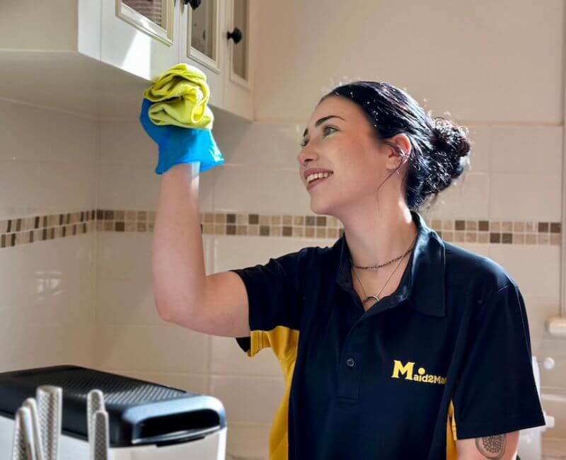 Maid2Match Adelaide house cleaner Alice wiping down cabinet exteriors