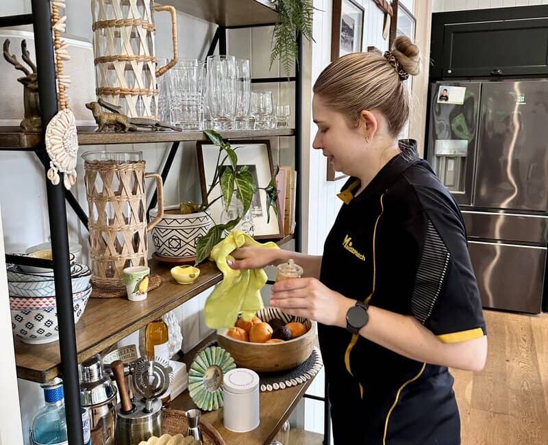 Maid2Match cleaner Kate-lyn cleaning shelves in living area