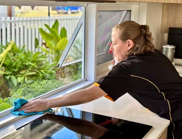 Maid2Match professional house cleaner Nicole cleaning a stovetop