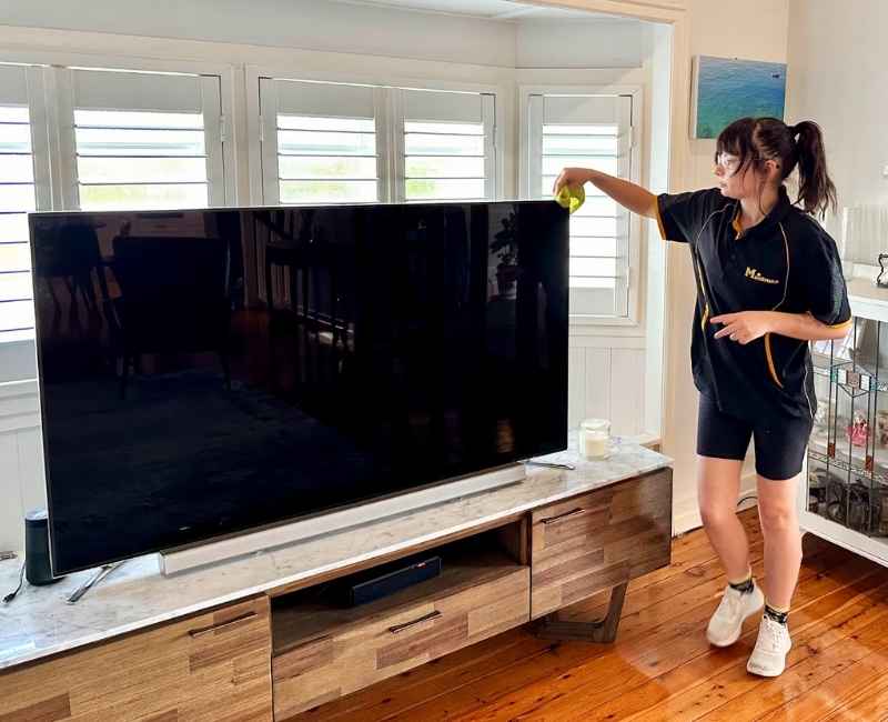 Tullie wiping TV corners with microfibre cloth
