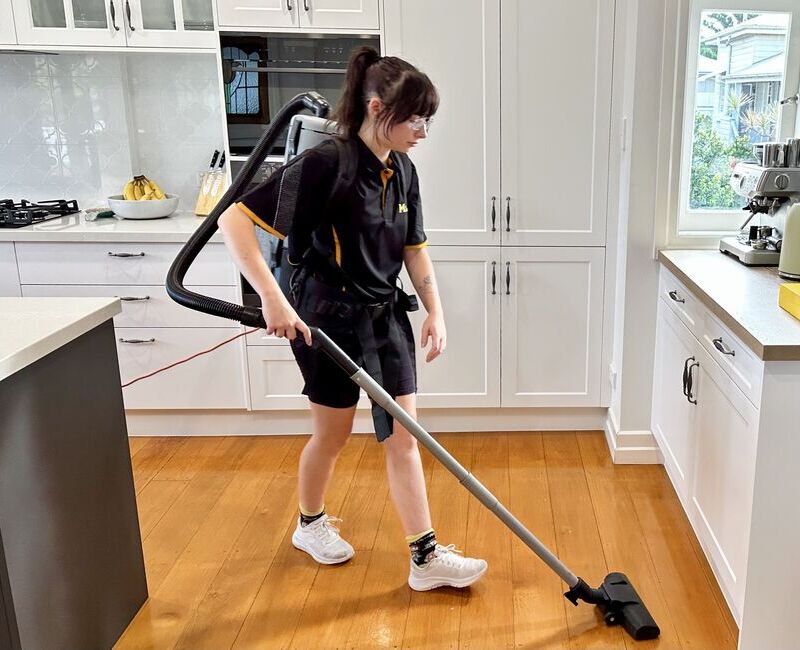 Maid2Match Brisbane cleaner Tullie vacuuming the kitchen floor