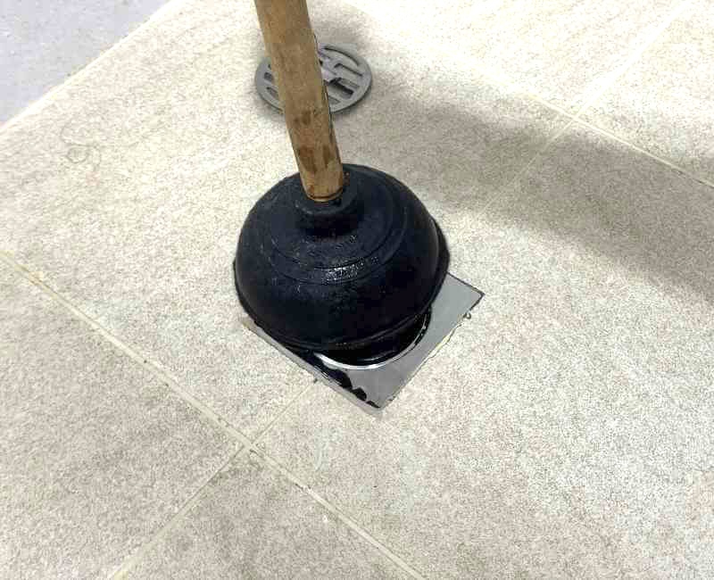 Using cup plunger to unclog shower drain