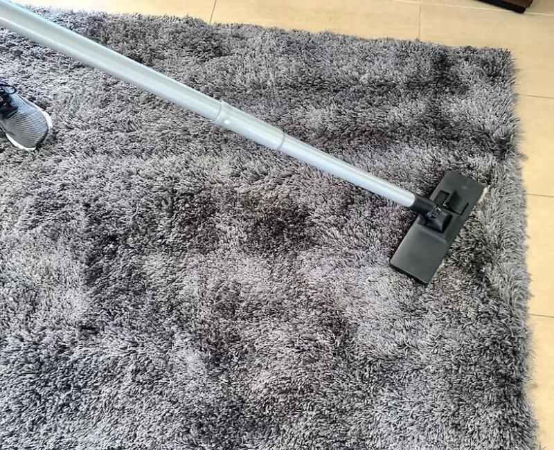 Maid2Match cleaner uses vacuum to clean a shag rug