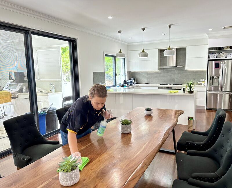 employee-house-cleaner-cleaning-dining-table Professional house cleaner Acama cleaning dining table