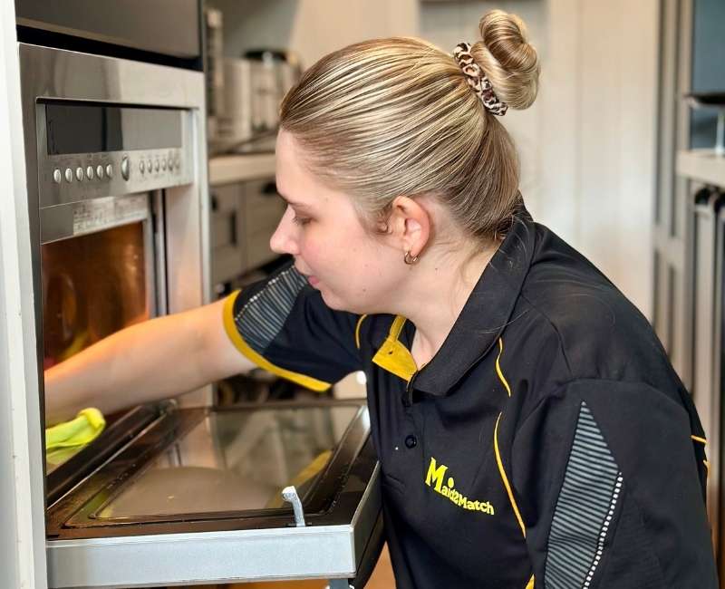 Maid2Match-NDIS-cleaner-Kate-Lyn-cleaning-microwave-oven Maid2Match NDIS cleaner Kate-Lyn cleaning a microwave interior