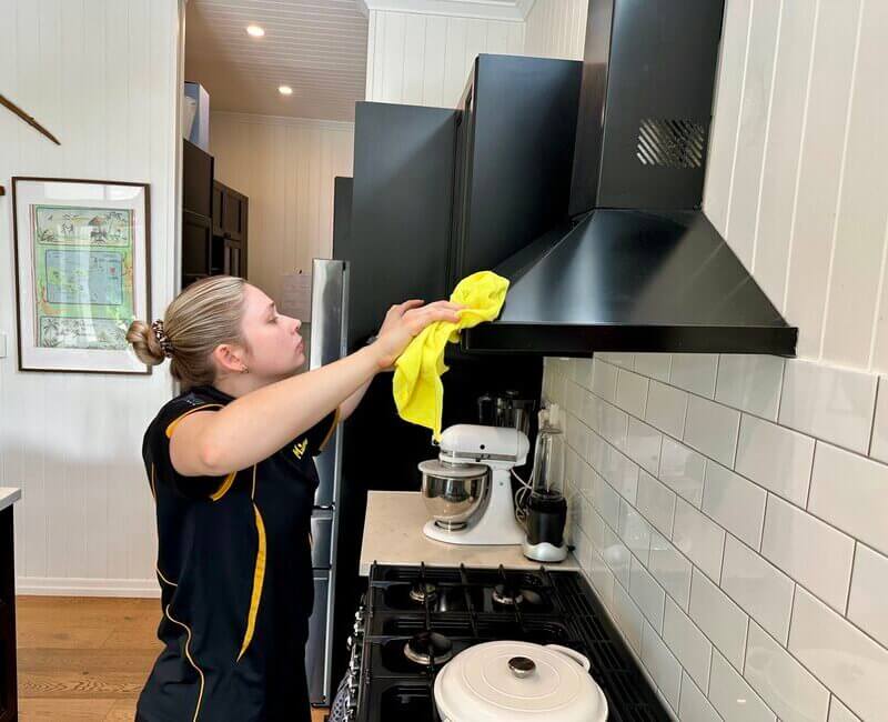 professional-house-cleaner-cleaning-rangehood Maid2Match professional house cleaner Kate-Lyn cleaning a rangehood inside the kitchen