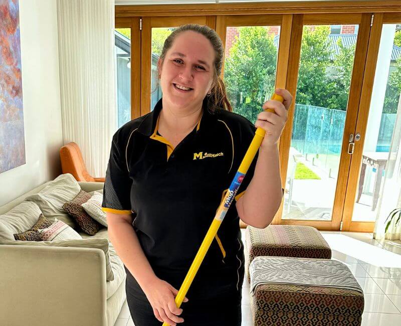 Maid2Match-professional-house-cleaner-Brooke-holding-a-mop Maid2Match house cleaner Brooke smiling while holding a mop