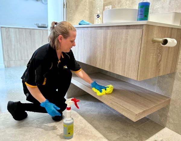 Maid2Match professional house cleaner Nicole cleaning under-sink shelf