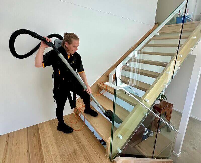 professional-house-cleaner-Nicole-vaccuming-stairs Maid2Match employee house cleaner Nicole vacuuming the stairs