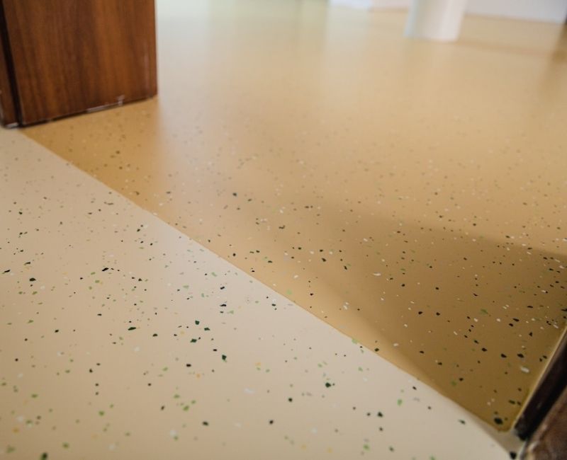 Two-toned speckled yellow epoxy flooring up close