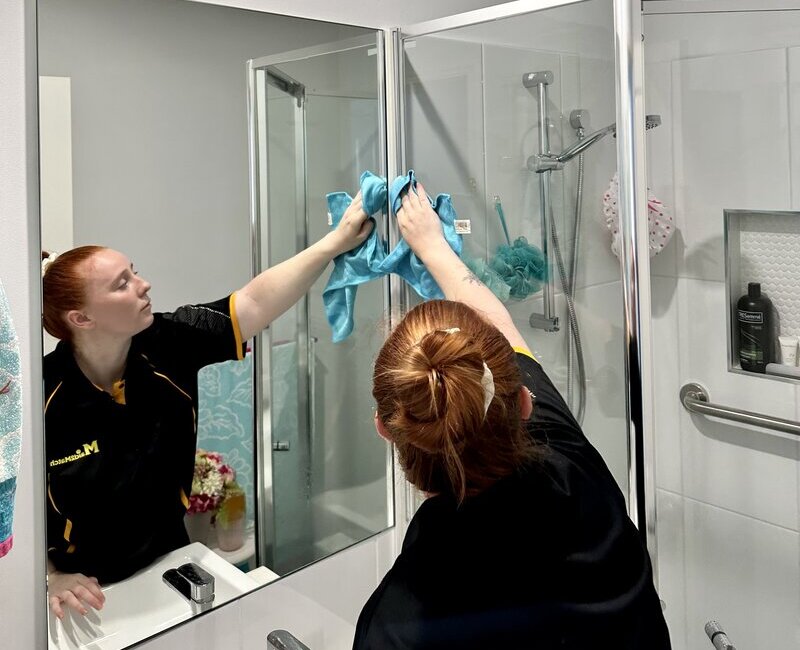 employee-cleaner-cleaning-shower-glass Maid2Match professional cleaner cleaning shower glass