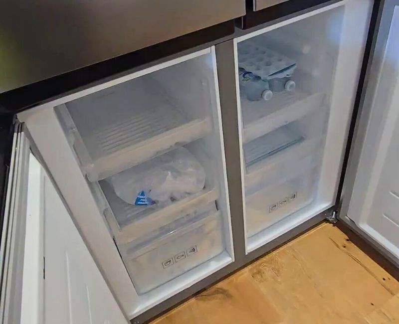 newly-cleaned-freezer-with-open-doors Newly cleaned and organised freezer with ice and frozen water bottles