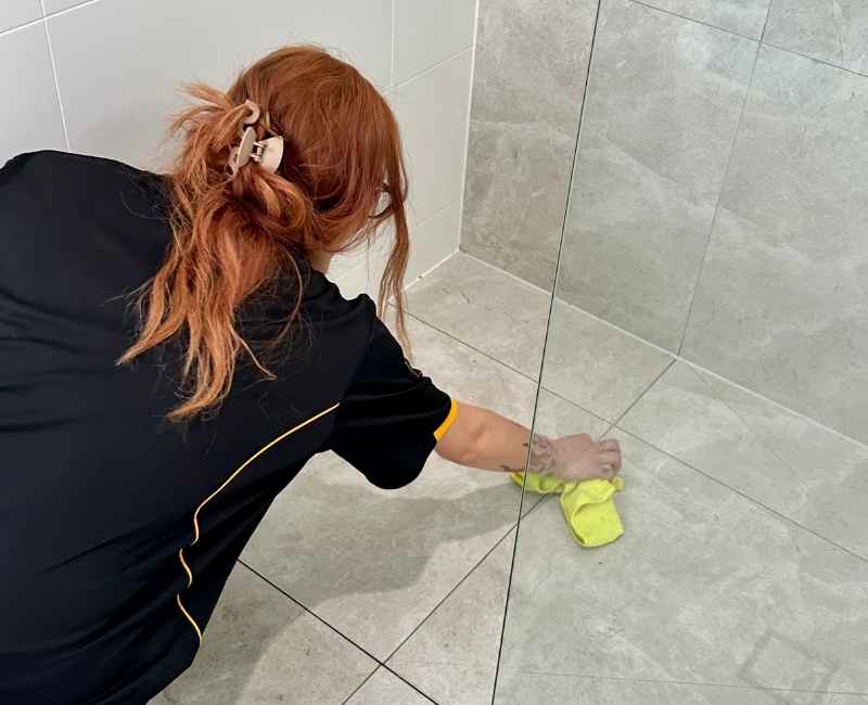 Maid2Match house cleaner Mariachiara cleaning shower tile grout with microfibre cloth